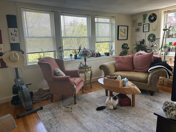 a living room with furniture fireplace and a large window