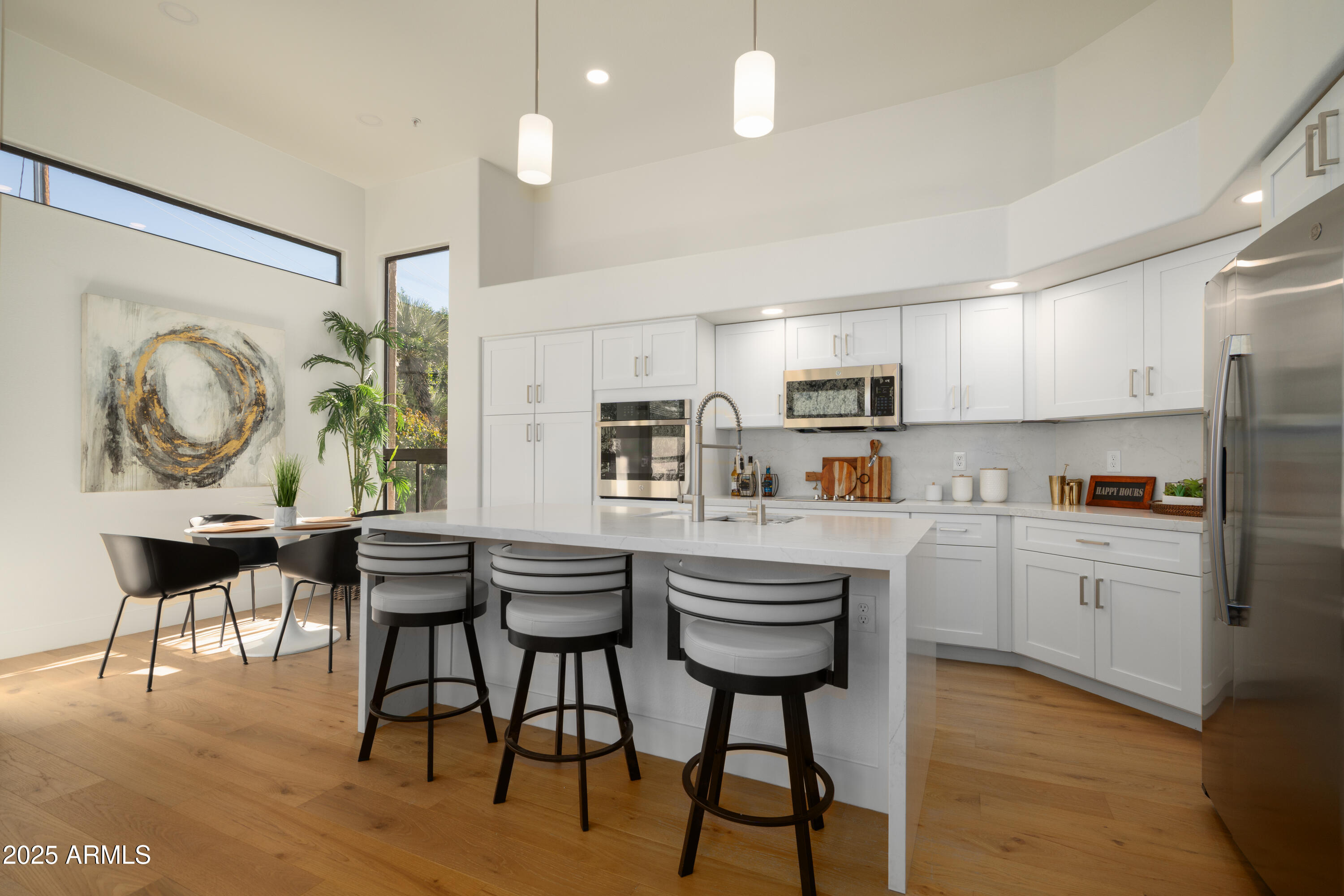 8100 East Camelback Road, Unit 175 Scottsdale, AZ 85251 - Photo 2 of 25 a kitchen with kitchen island granite countertop a table chairs a sink and a refrigerator
