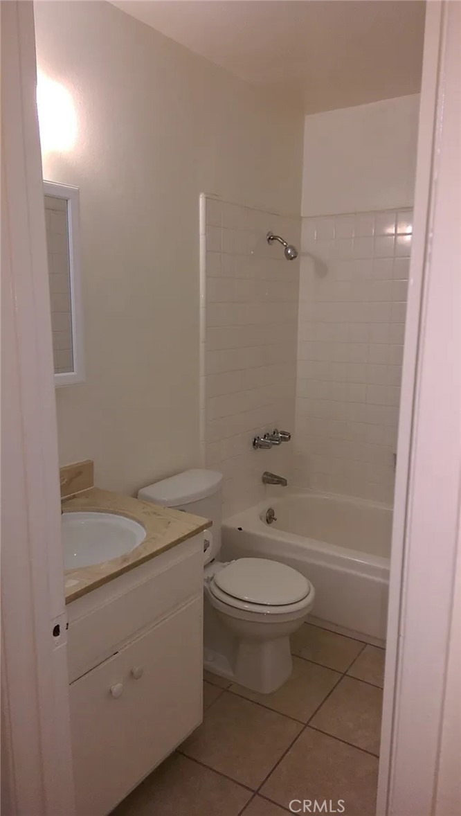 160 West Cascade Drive Rialto, CA 92376 - Photo 15 of 28 a bathroom with a granite countertop toilet a sink and a mirror