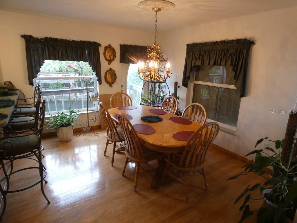5260 Tuna Lane Weeki Wachee, FL 34607 - Photo 15 of 34 a view of a dining room with furniture window and wooden floor