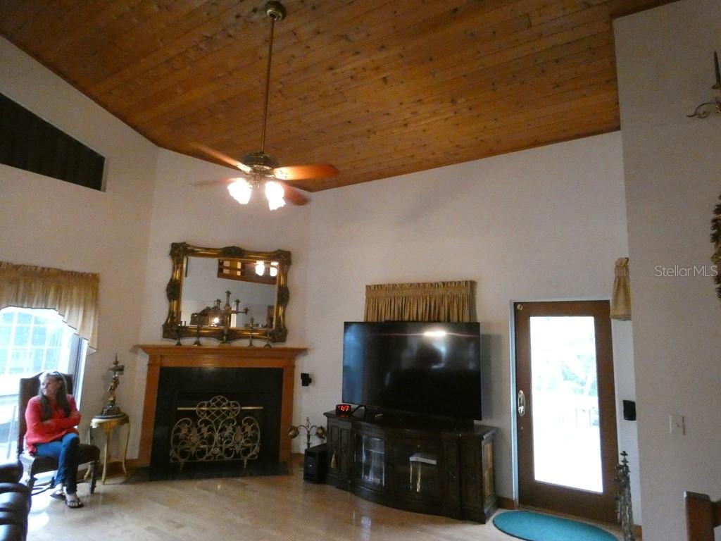 5260 Tuna Lane Weeki Wachee, FL 34607 - Photo 22 of 34 a living room with furniture a flat screen tv and a fireplace