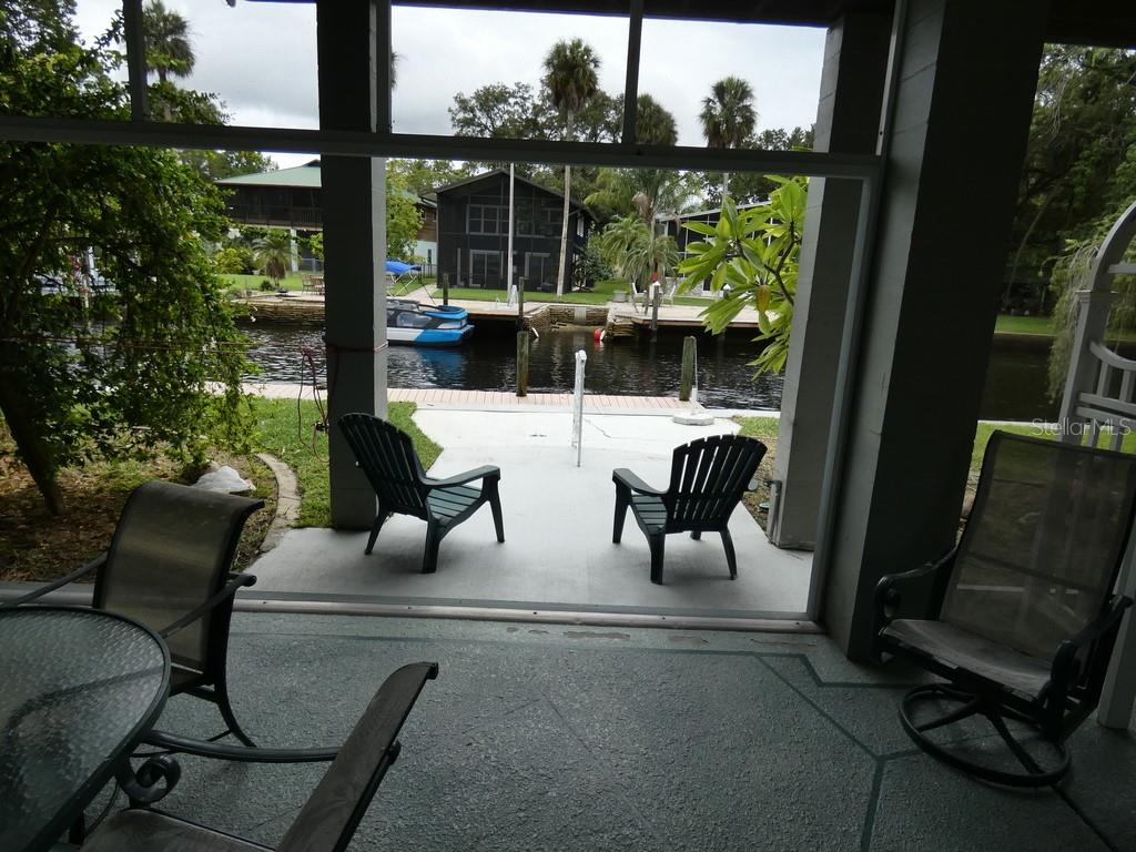 5260 Tuna Lane Weeki Wachee, FL 34607 - Photo 30 of 34 a living room with patio furniture and a floor to ceiling window