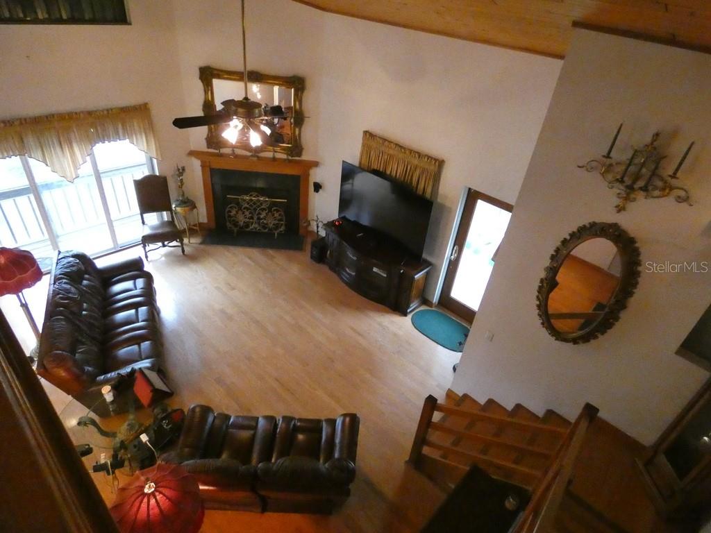 5260 Tuna Lane Weeki Wachee, FL 34607 - Photo 6 of 34 a living room with furniture a flat screen tv and a fireplace