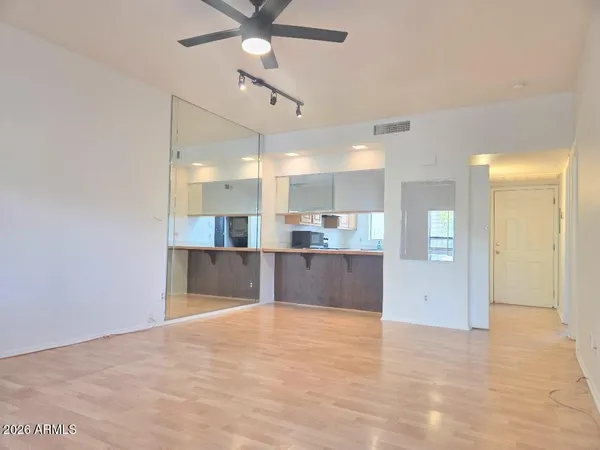 a view of an empty room with a window and wooden floor