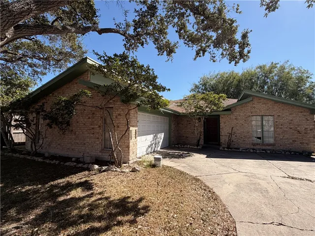 a front view of a house with a yard covered with snow