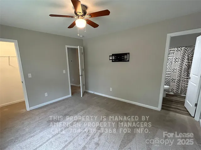 an empty room with closet and a ceiling fan