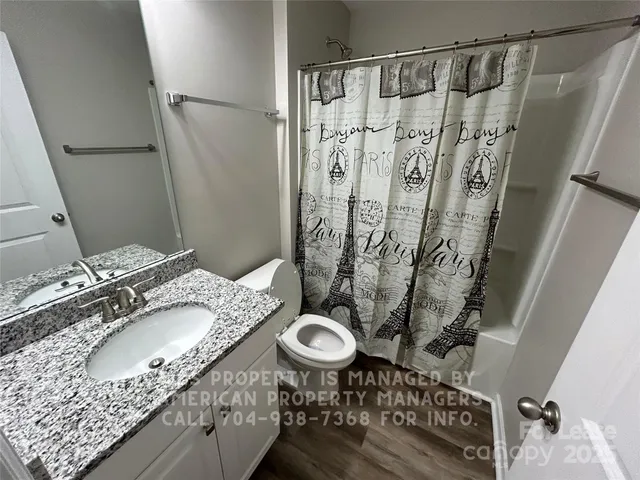 a bathroom with a granite countertop sink a mirror and shower