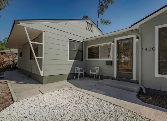 a backyard of a house with table and chairs