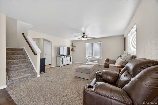 a living room with furniture and a ceiling fan