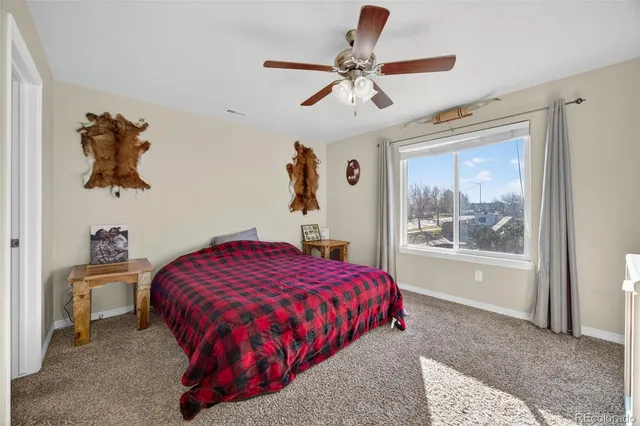 a bedroom with a bed and a painting on the wall