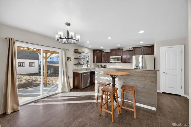 a kitchen with stainless steel appliances kitchen island granite countertop a refrigerator and cabinets