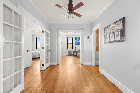 a view of a livingroom with wooden floor and a ceiling fan