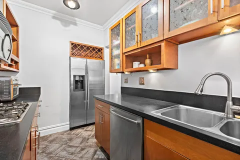 a kitchen with stainless steel appliances granite countertop a sink and a refrigerator