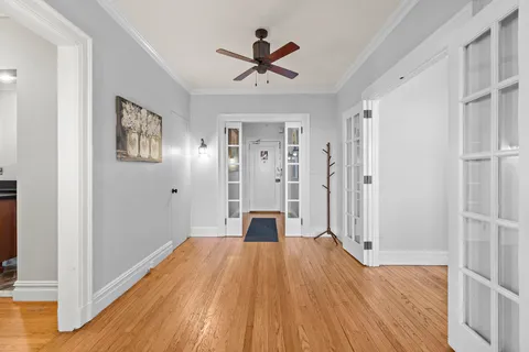 a view of a room with wooden floor a ceiling fan
