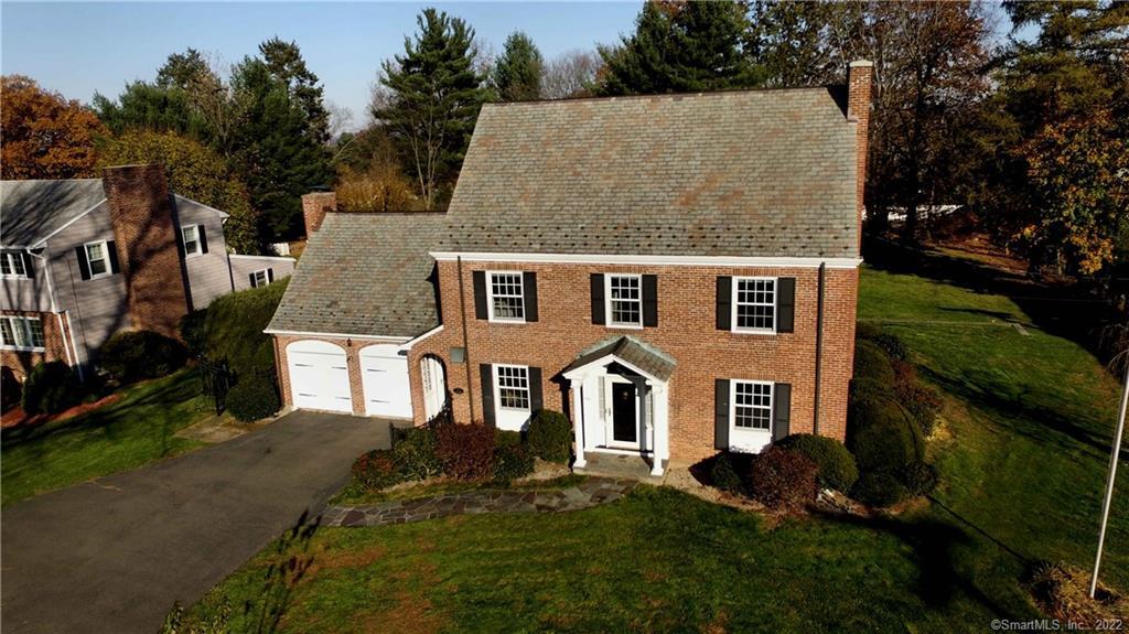 724 Ridge Road Wethersfield, CT 06109 - Photo 1 of 1 a view of a white house with a yard plants and large tree