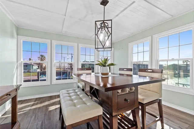 a view of a dining room and livingroom with furniture wooden floor a chandelier