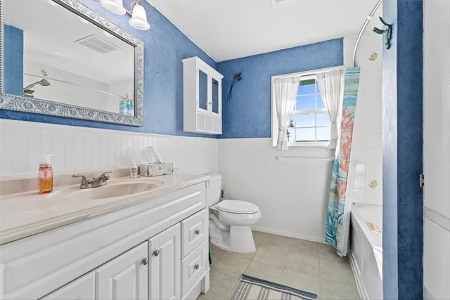 a bathroom with a granite countertop toilet sink and a mirror