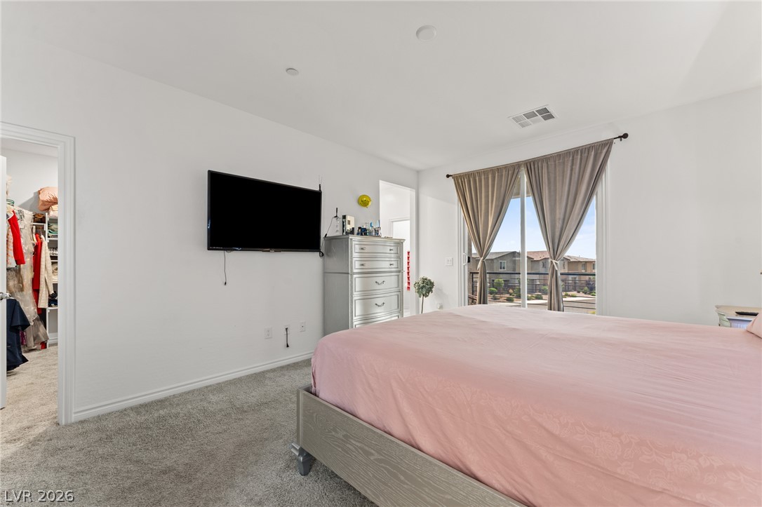 8879 Roadrunner Ravine Street Las Vegas, NV 89166 - Photo 26 of 39 Sun-filled bedroom featuring plush carpeting and generous windows for ample light.