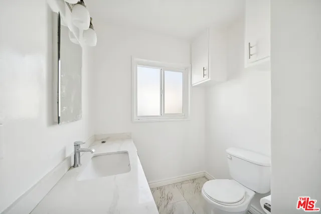 a white toilet sitting next to a bathroom sink