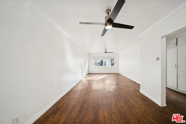 a view of a room with wooden floor staircase and a ceiling fan