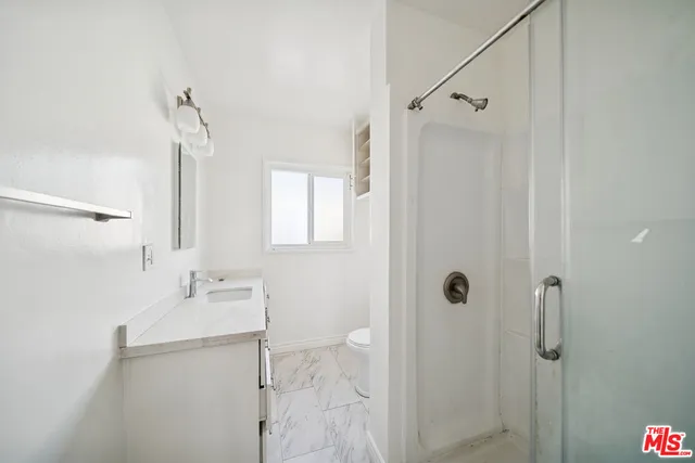 a bathroom with a sink vanity granite tub shower and mirror