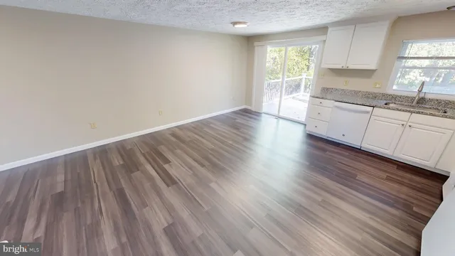 a view of a kitchen with wooden floor and a sink