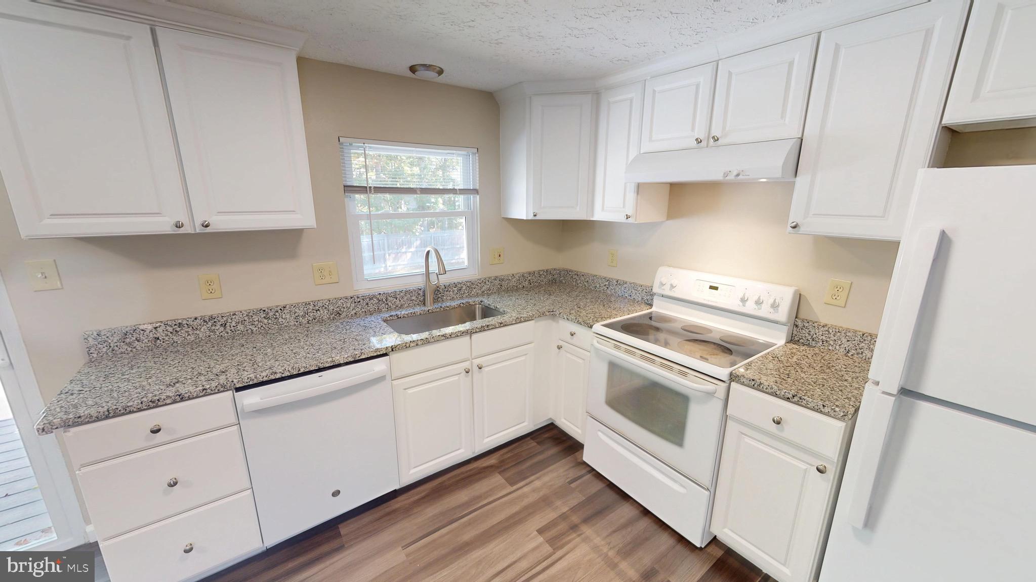 12820 Twin Oak Drive Waldorf, MD 20601 - Photo 21 of 98 a kitchen with granite countertop white cabinets and white appliances