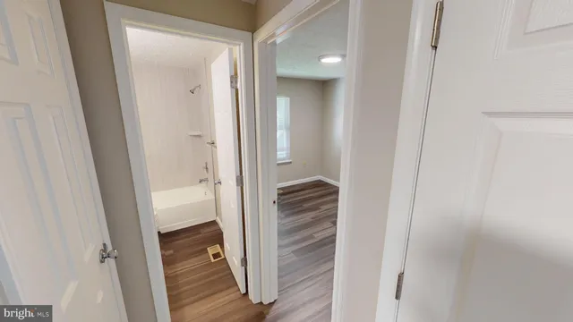 a view of a hallway with wooden floor and closet
