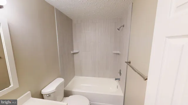 a view of an empty room with wooden floor and closet