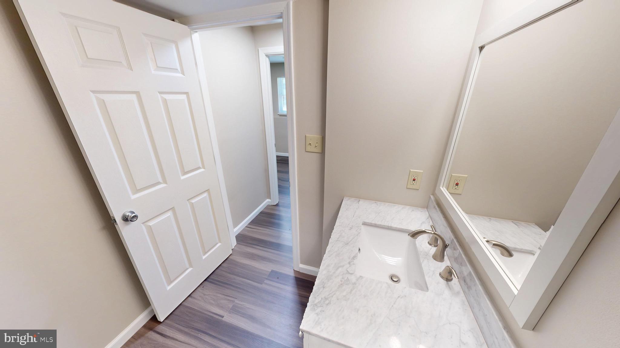 12820 Twin Oak Drive Waldorf, MD 20601 - Photo 57 of 98 a view of a hallway with wooden floor and staircase