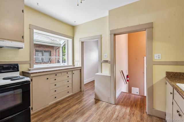 a kitchen with wooden floors and white appliances