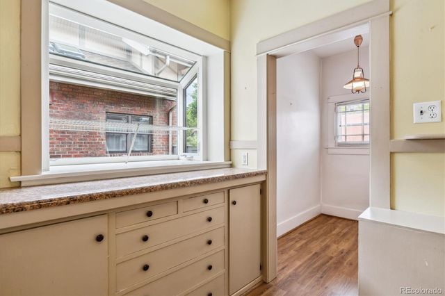 a kitchen with granite countertop white cabinets and a window