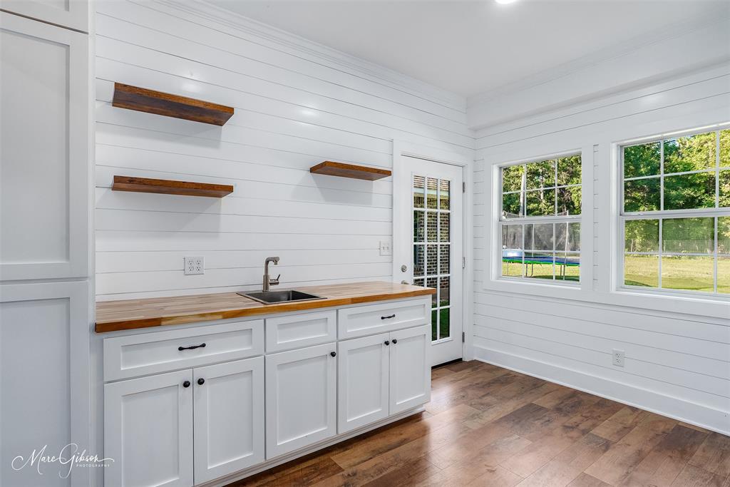 550 Linton Bellevue Road Benton, LA 71006 - Photo 31 of 37 Entry to mudroom with coffee station or wetbar with butcher block counters, open shelves, white cabinets and wood laminate flooring