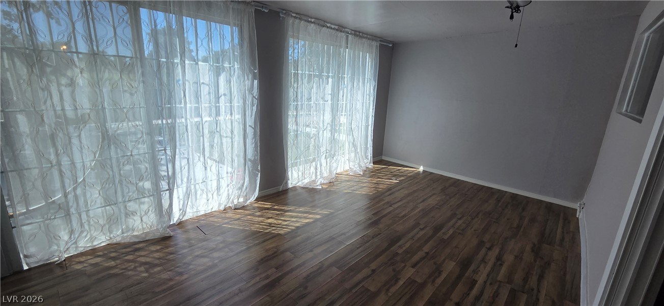 Rich wood-look flooring anchors this versatile living space filled with natural light.