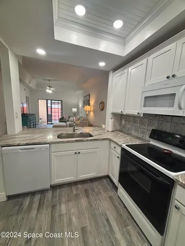 a kitchen with granite countertop cabinets stainless steel appliances and a sink
