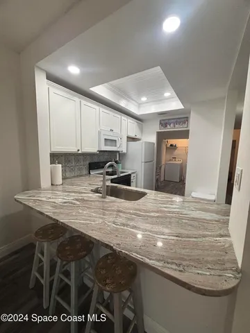 a view of kitchen with stainless steel appliances granite countertop sink stove and cabinets