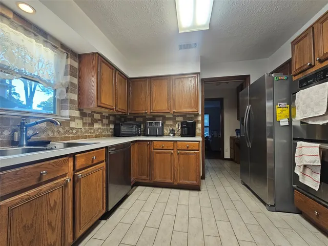 a kitchen with stainless steel appliances granite countertop a sink and cabinets