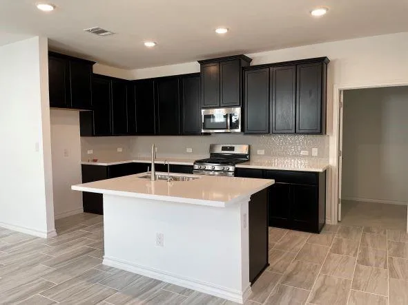 a kitchen with stainless steel appliances granite countertop a stove and a refrigerator