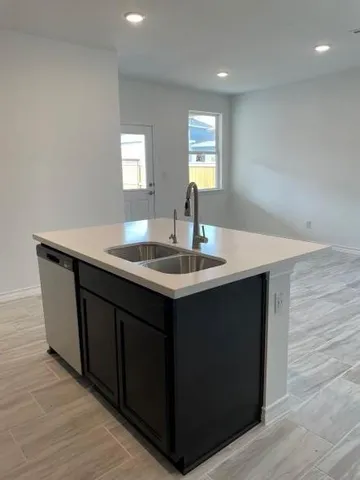 a kitchen with granite countertop a stove top oven a sink and dishwasher a refrigerator with wooden floors