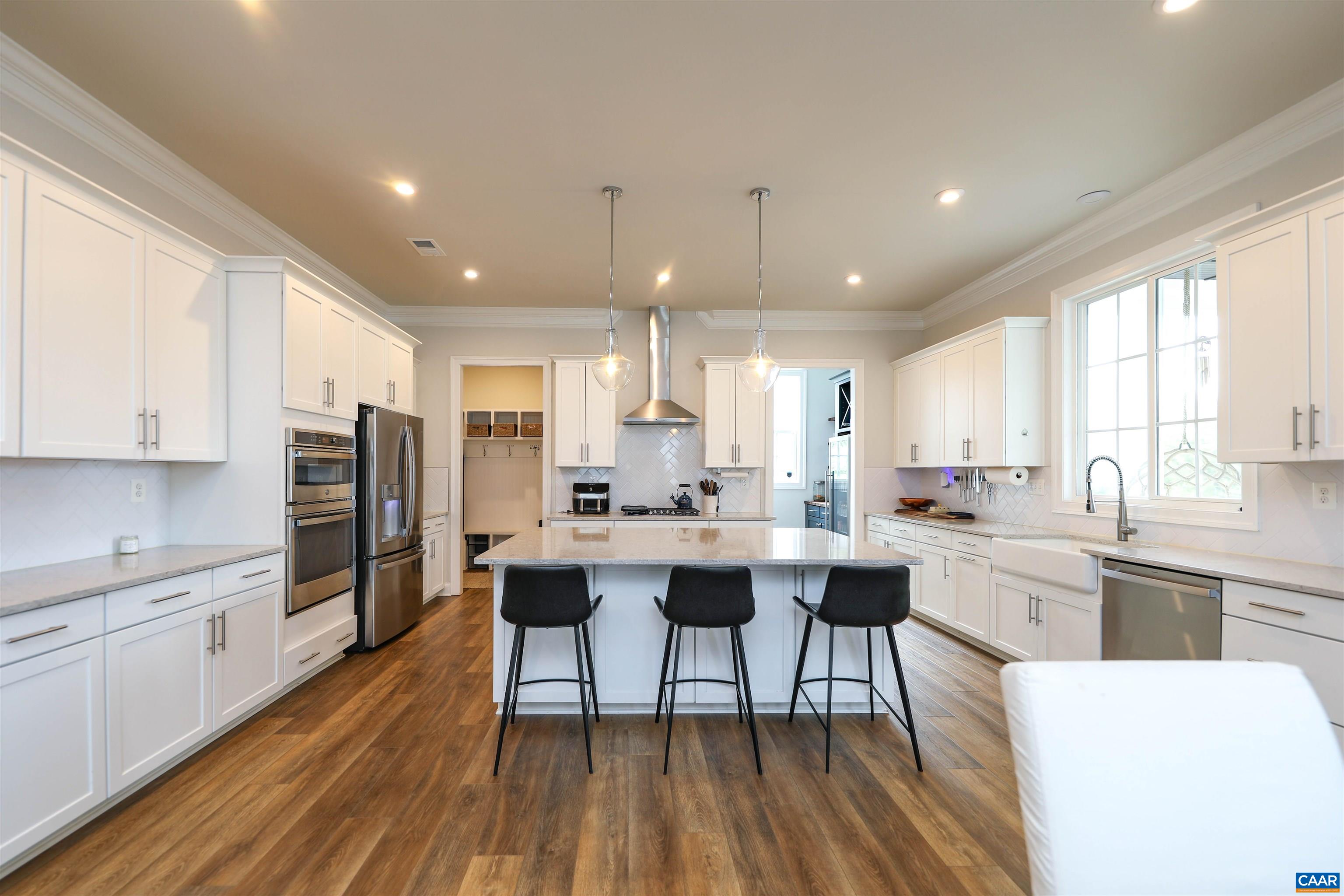2483 Ferndown Lane Keswick, VA 22947 - Photo 11 of 54 a kitchen with stainless steel appliances a dining table chairs stove refrigerator and cabinets