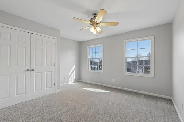 a view of an empty room with a window and a ceiling fan