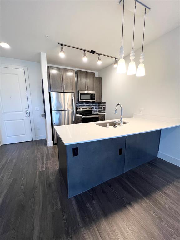 6080 Water Street, Unit 1462 Plano, TX 75024 - Photo 2 of 9 a kitchen with kitchen island wooden floors white cabinets and stainless steel appliances