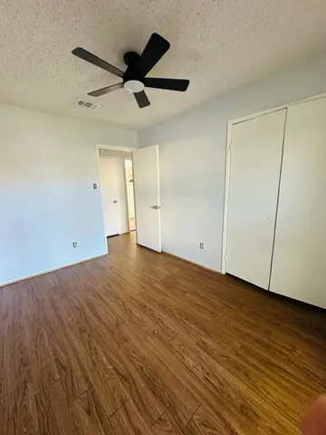 a view of empty room with wooden floor