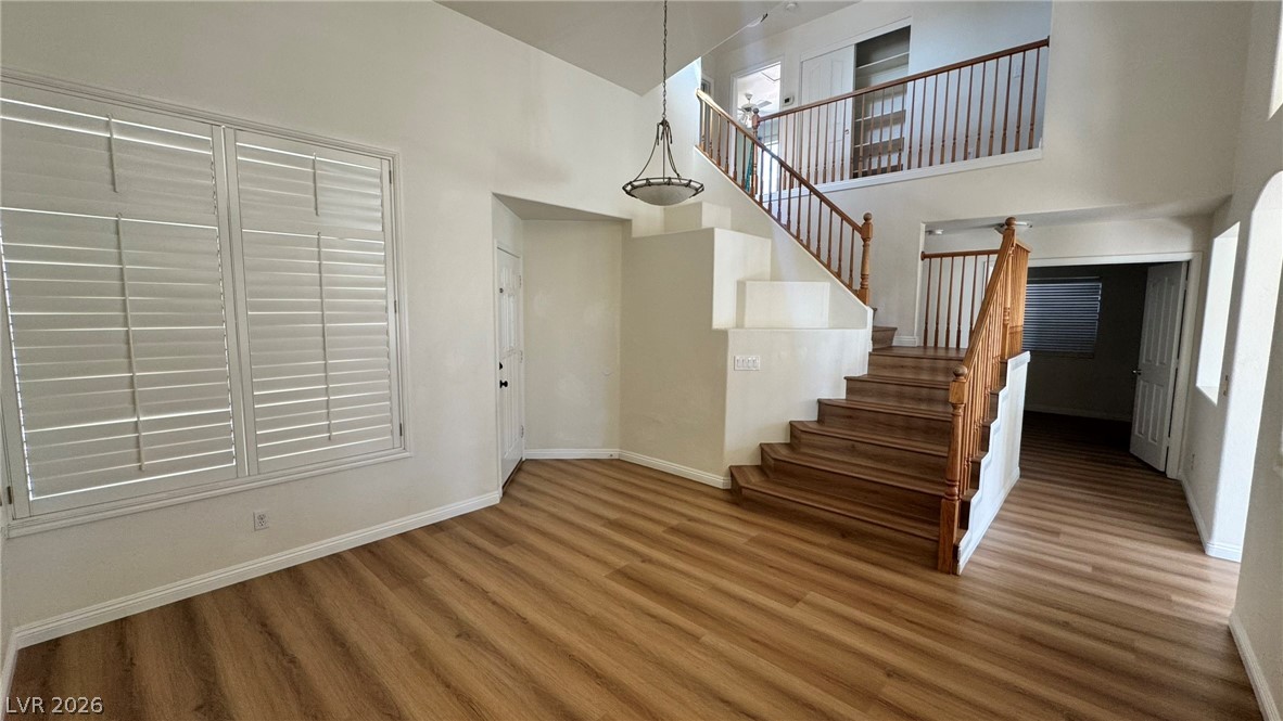 9716 Ridge Creek Place Las Vegas, NV 89134 - Photo 4 of 28 This bright interior features wood flooring, a staircase with wooden railing, and natural light.