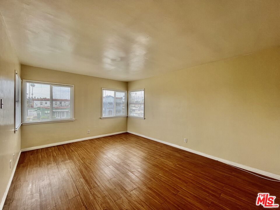 4424 1/2 Arlington Avenue Los Angeles, CA 90043 - Photo 3 of 10 a view of an empty room with wooden floor and a window