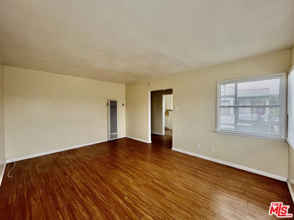 4424 1/2 Arlington Avenue Los Angeles, CA 90043 - Photo 4 of 10 a view of an empty room with wooden floor and a window