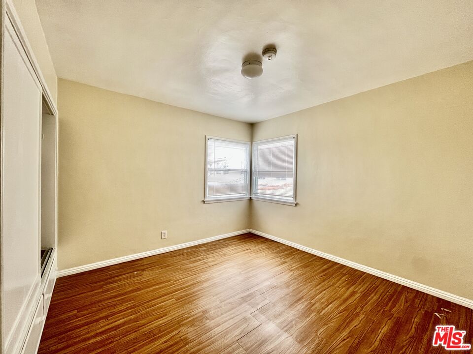 4424 1/2 Arlington Avenue Los Angeles, CA 90043 - Photo 8 of 10 an empty room with wooden floor and windows