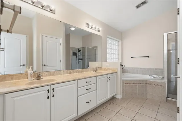 a spacious bathroom with a granite countertop sink a toilet a mirror and shower