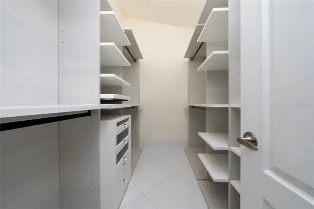 a kitchen with a refrigerator and white cabinets