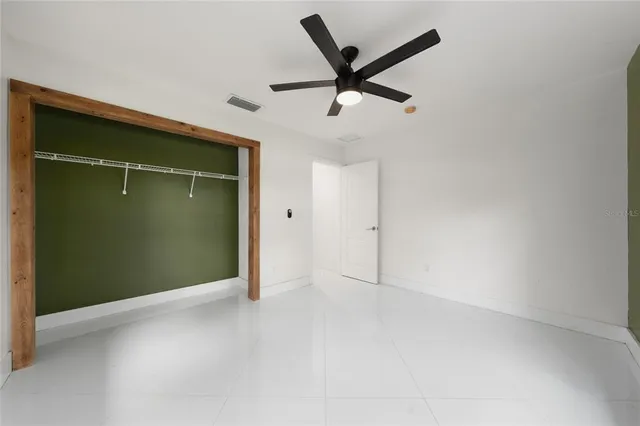 an empty room with closet and windows